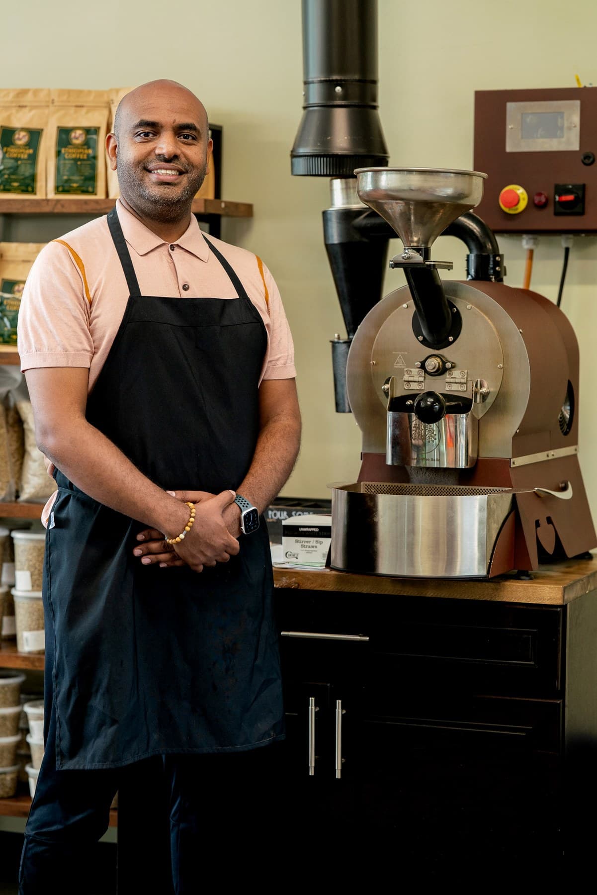 Buna House team member standing beside the coffee roaster