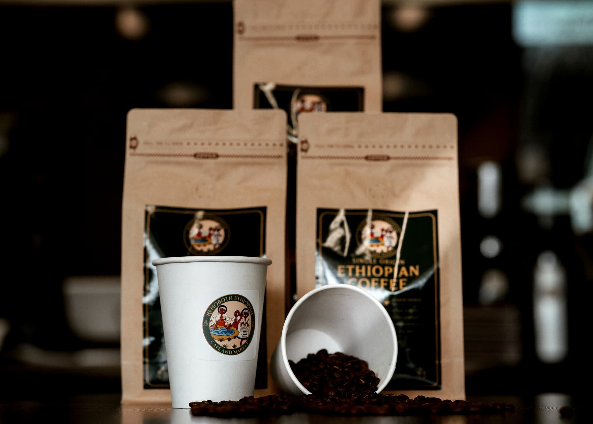 Buna House coffee bags with branded cups and roasted beans on the counter